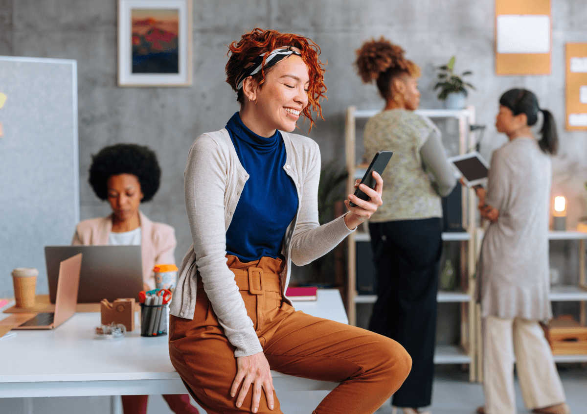 Image of woman sitting a table looking at her phone