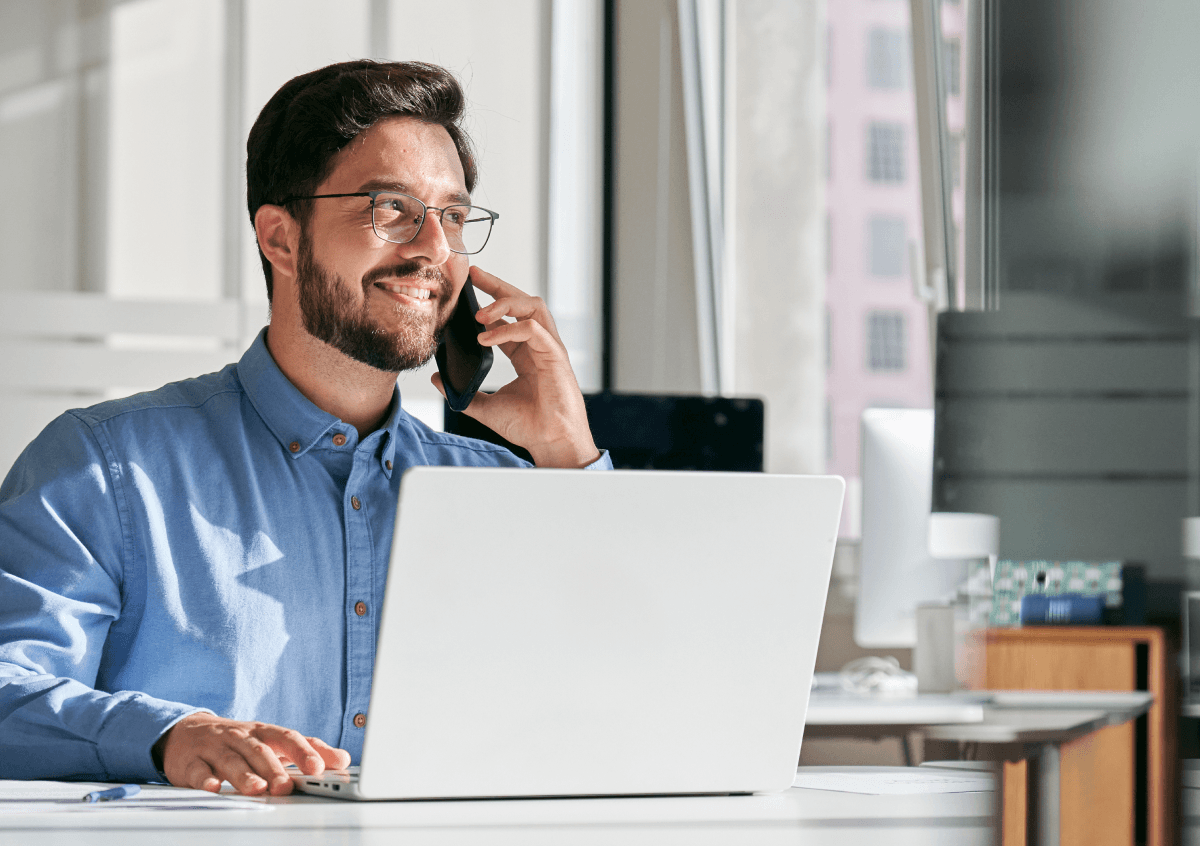 Image of man on the phone with a laptop in front of him